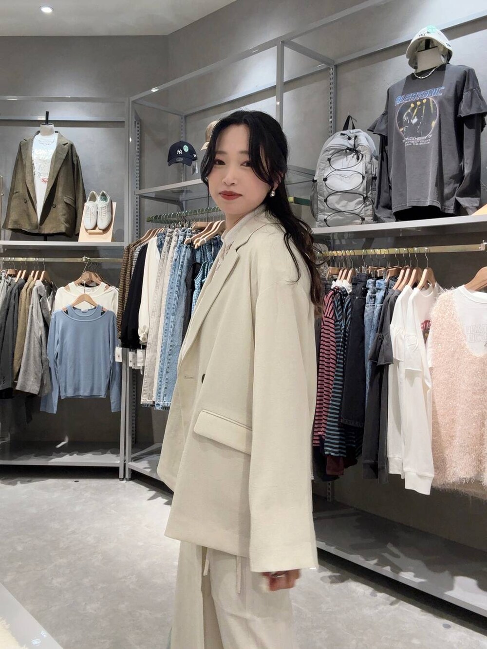 ホワイト系のスカート、ホワイト系のテーラードジャケット、グリーン系のトートバッグを着用したレディースの春コーディネートの5枚目の写真