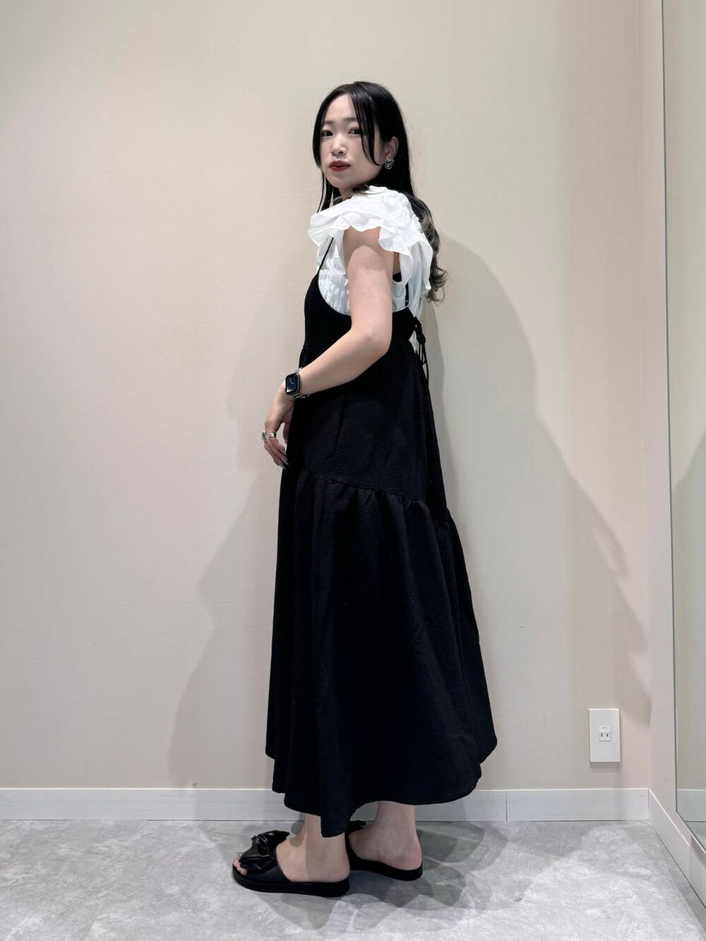 ブラック系のワンピース、ブラック系のショルダーバッグ、ブラック系のサンダルを着用したレディースの夏コーディネートの3枚目の写真