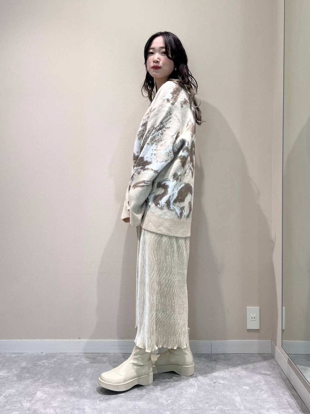 ホワイト系のショルダーバッグ、ホワイト系のTシャツ/カットソー、ホワイト系のブーツを着用したレディースの冬コーディネートの3枚目の写真