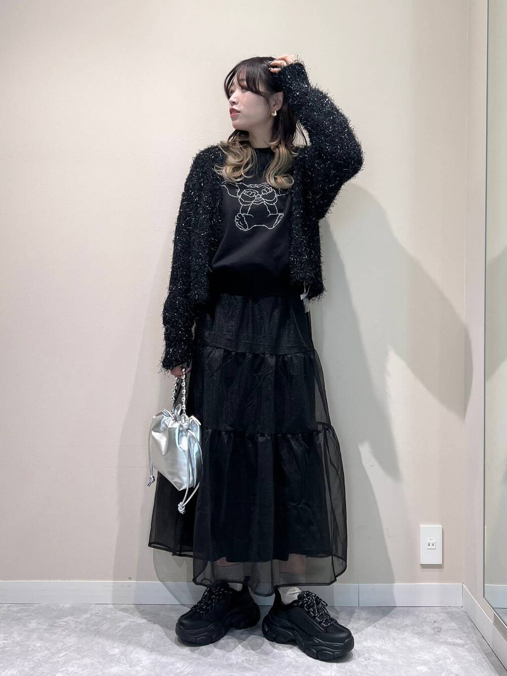 ブラック系のカーディガン/ボレロ、ブラック系のスカート、ブラック系のスニーカーを着用したレディースの冬コーディネートの2枚目の写真