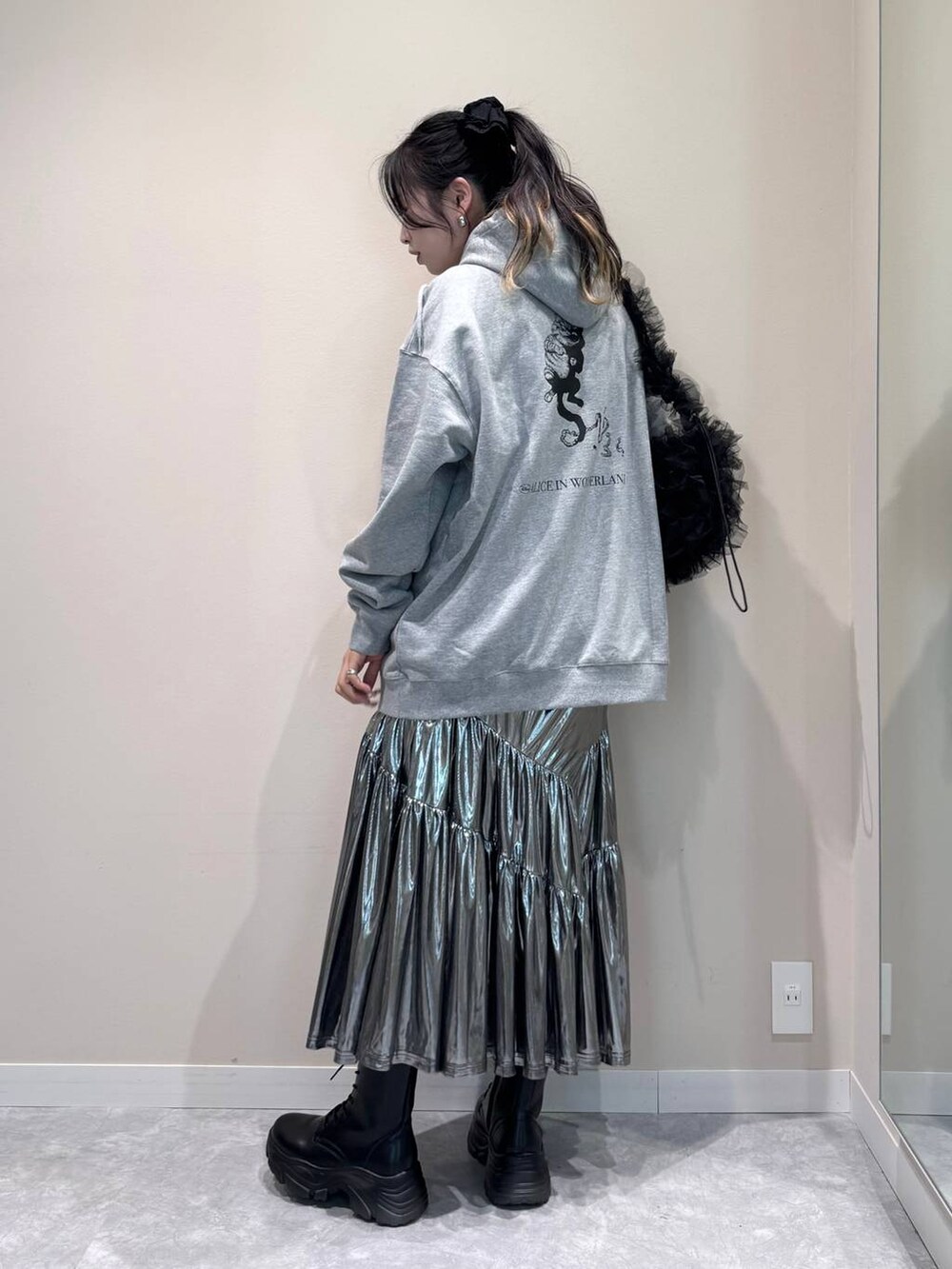 グレー系のスカート、グレー系のスウェット、ブラック系のショルダーバッグを着用したレディースの秋コーディネートの3枚目の写真