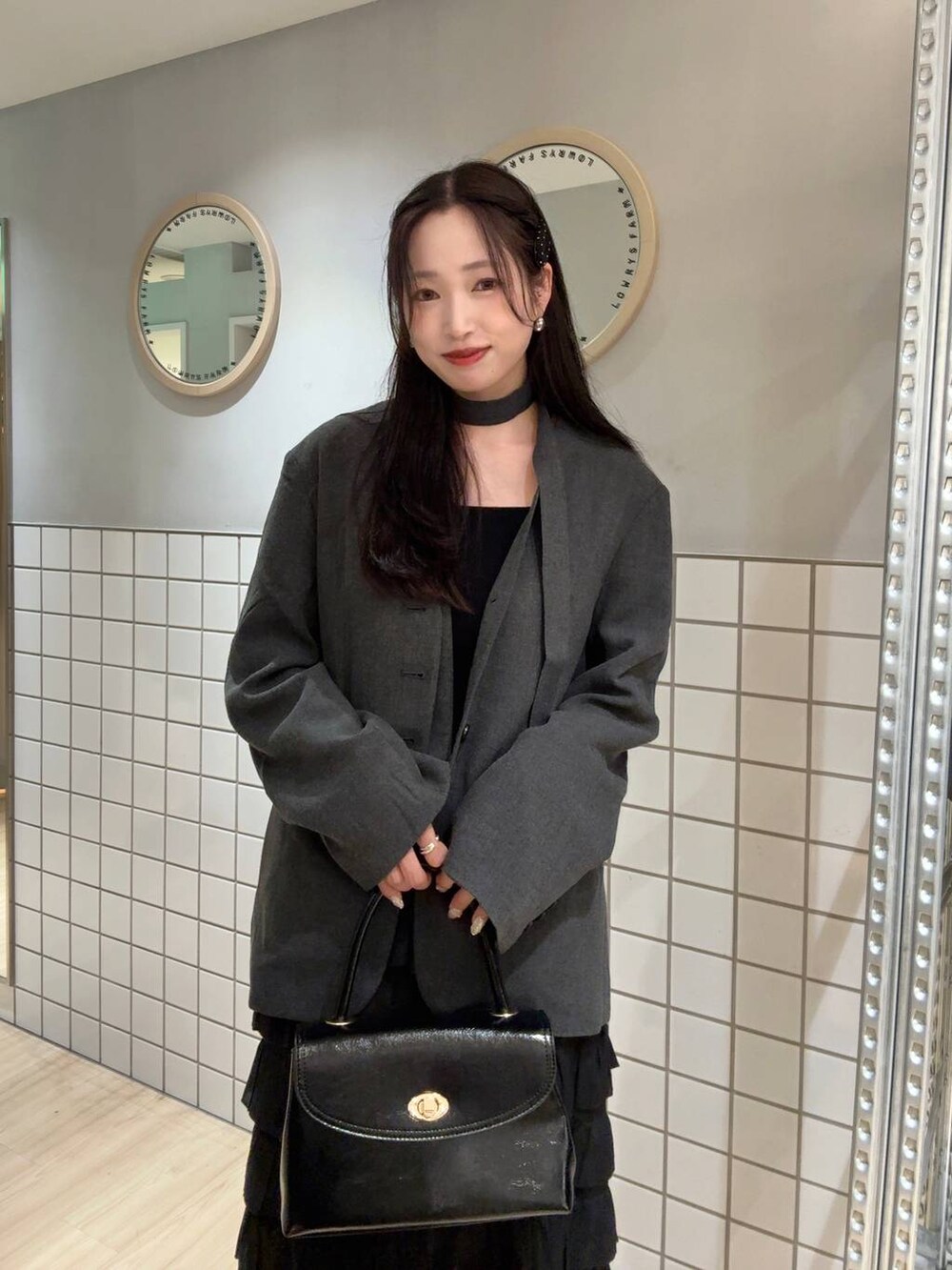 ブラック系のタンクトップ、グレー系のテーラードジャケット、ブラック系のボストンバッグを着用したレディースの秋コーディネートの5枚目の写真