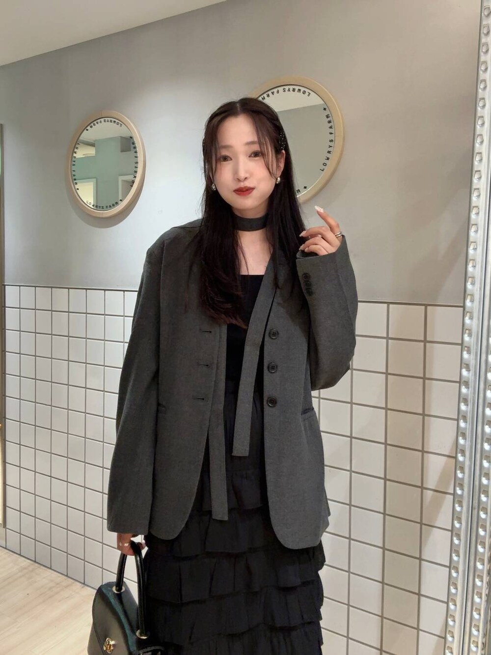 ブラック系のタンクトップ、グレー系のテーラードジャケット、ブラック系のボストンバッグを着用したレディースの秋コーディネートの4枚目の写真