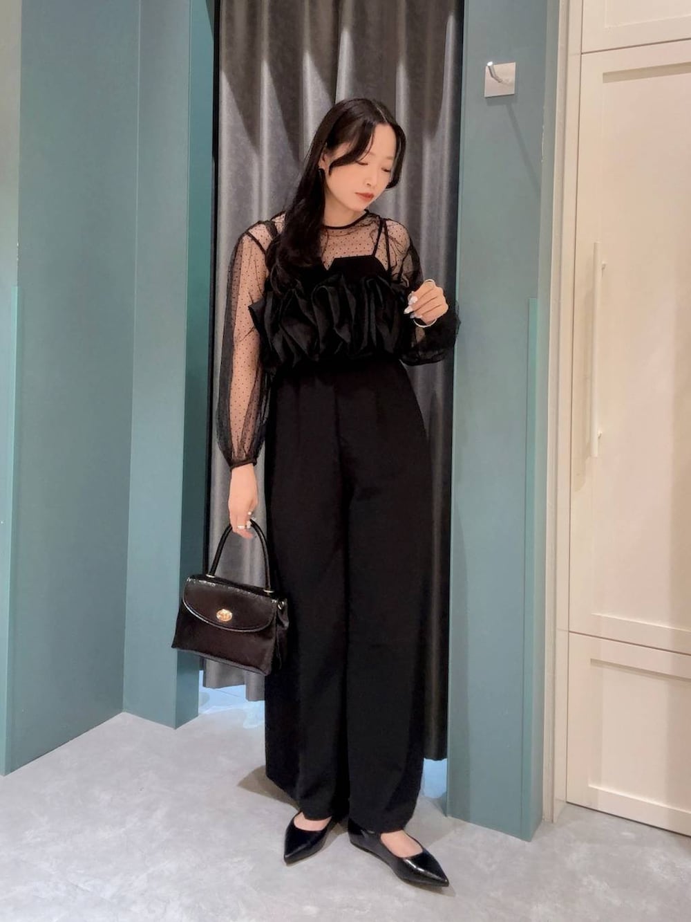 ブラック系のボストンバッグ、ブラック系のワンピース、ブラック系のパンプスを着用したレディースの夏コーディネートの2枚目の写真