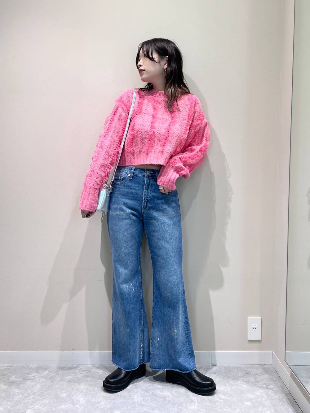 その他のデニムパンツ、ブラック系のブーツ、ピンク系のニット/セーターを着用したレディースの秋コーディネートの3枚目の写真