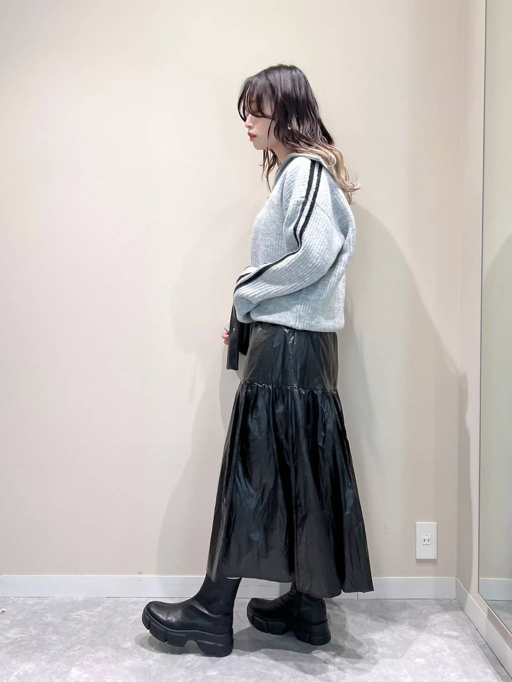 ブラック系のブーツ、ブラック系のショルダーバッグ、ブラック系のスカートを着用したレディースの冬コーディネートの3枚目の写真