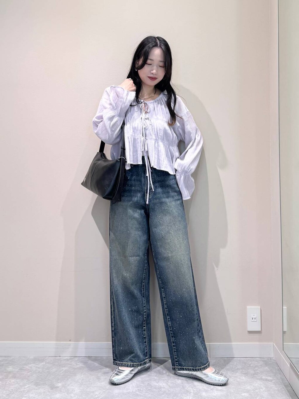 ブルー系のデニムパンツ、シルバー系のスニーカー、パープル系のシャツ/ブラウスを着用したレディースの春コーディネートの2枚目の写真