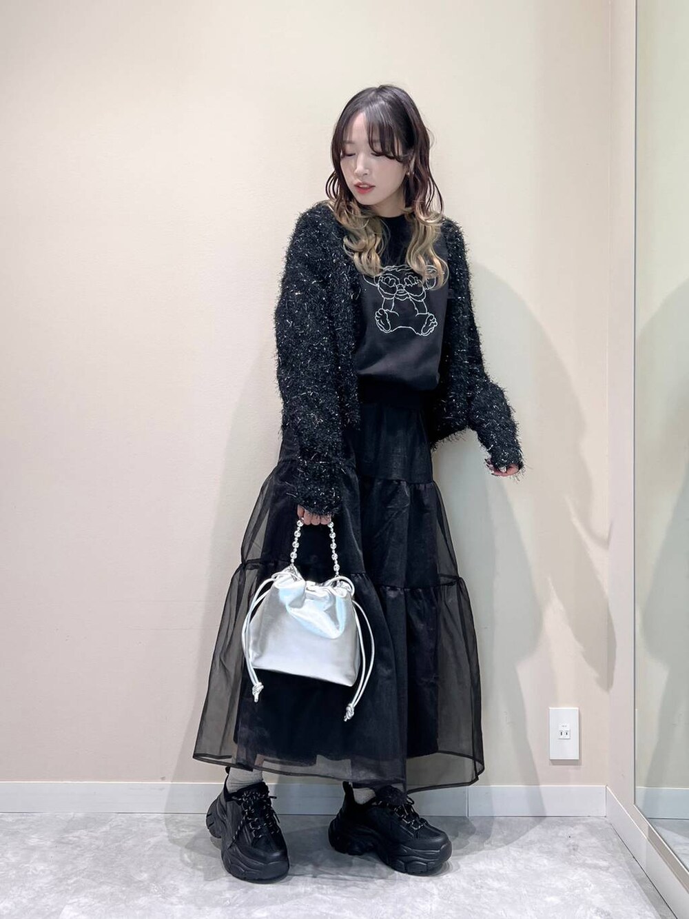 ブラック系のカーディガン/ボレロ、ブラック系のスカート、ブラック系のスニーカーを着用したレディースの冬コーディネートの5枚目の写真