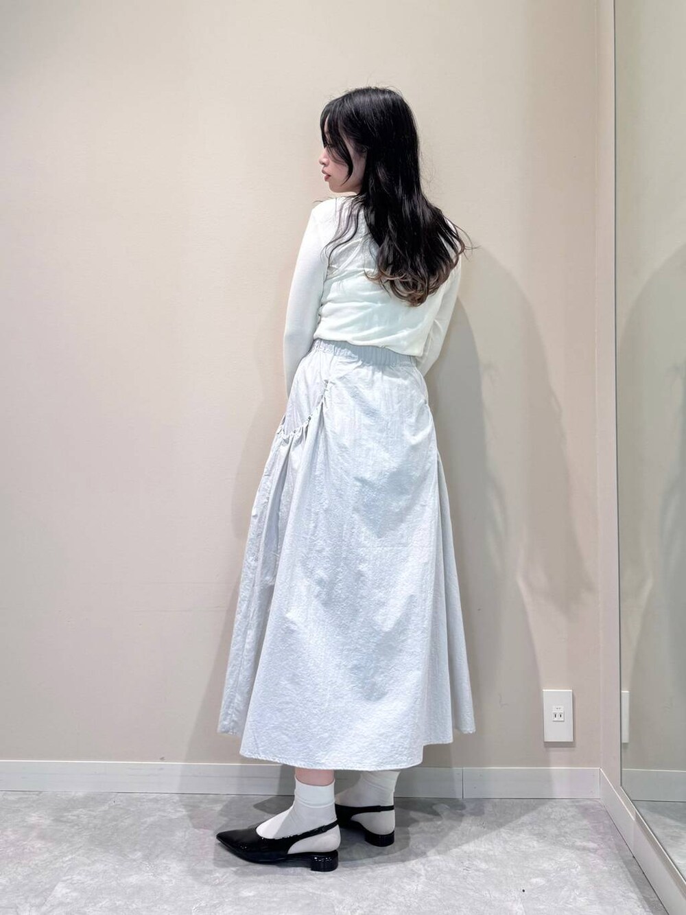 ブラック系のトートバッグ、ホワイト系のTシャツ/カットソー、ブラック系のパンプスを着用したレディースの春コーディネートの3枚目の写真