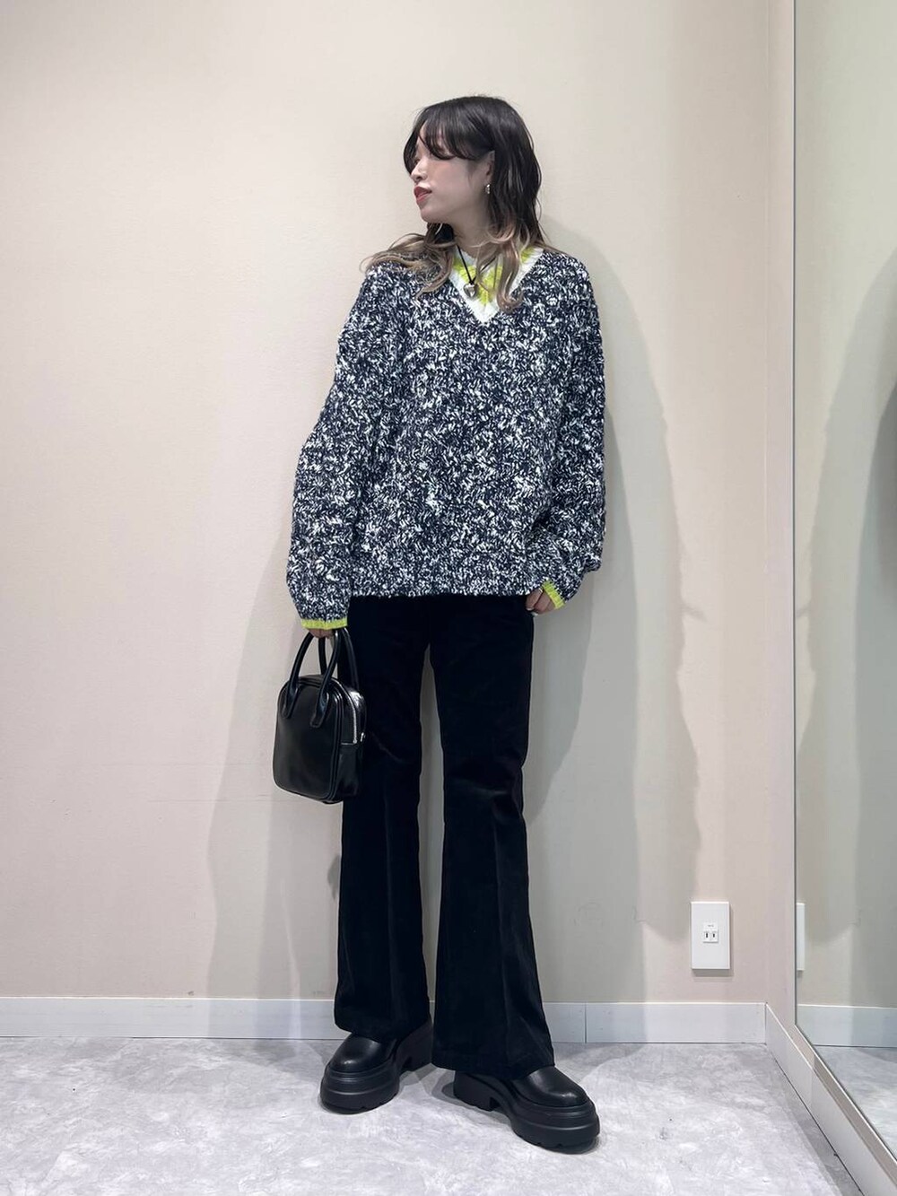 ブルー系のニット/セーター、ブラック系のブーツ、ブラック系のボストンバッグを着用したレディースの秋コーディネートの2枚目の写真