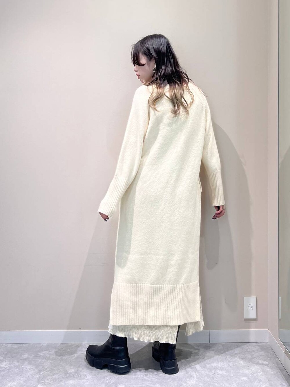 ブラック系のブーツ、ホワイト系のワンピース、ホワイト系のスカートを着用したレディースの冬コーディネートの3枚目の写真