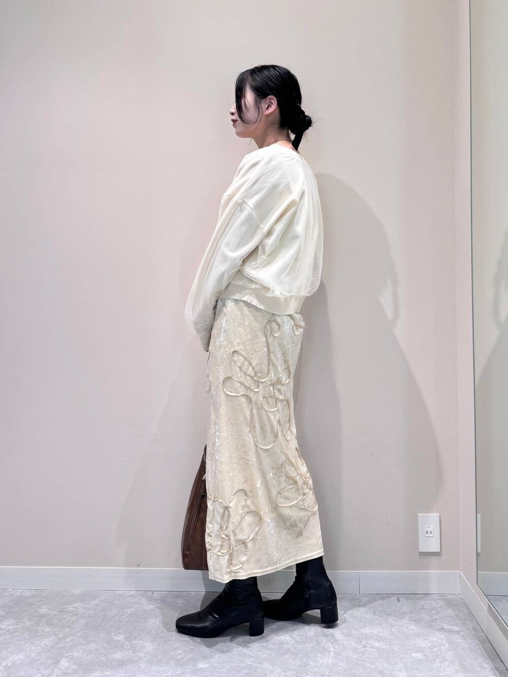 ホワイト系のニット/セーター、ブラック系のブーツ、ブラウン系のショルダーバッグを着用したレディースの秋コーディネートの4枚目の写真