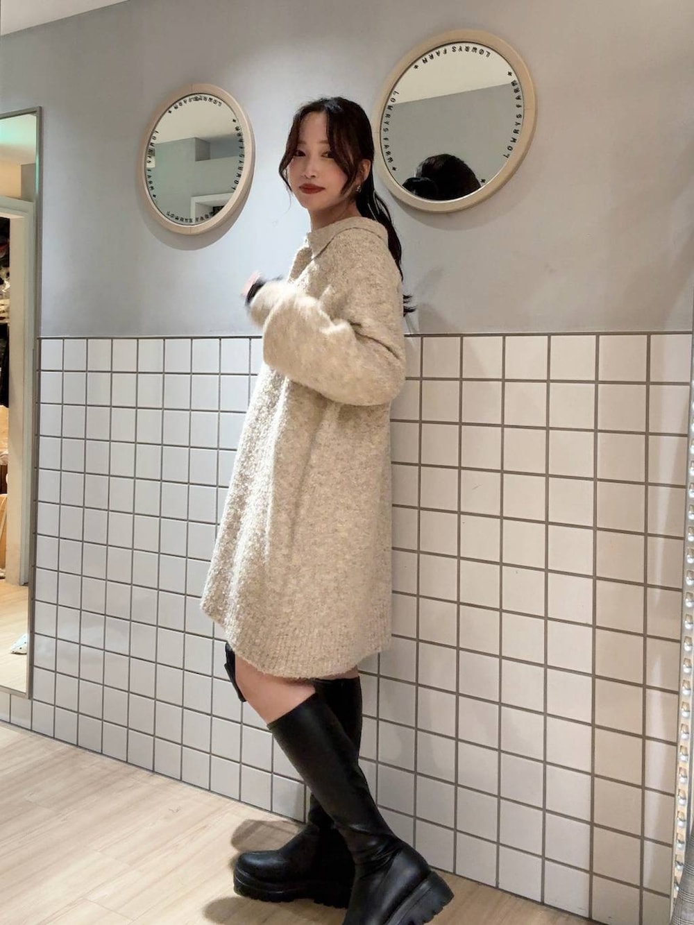 ブラック系のブーツ、ホワイト系のワンピース、ブラック系のショルダーバッグを着用したレディースの冬コーディネートの2枚目の写真