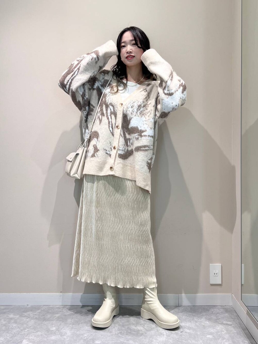 ホワイト系のショルダーバッグ、ホワイト系のTシャツ/カットソー、ホワイト系のブーツを着用したレディースの冬コーディネートの4枚目の写真