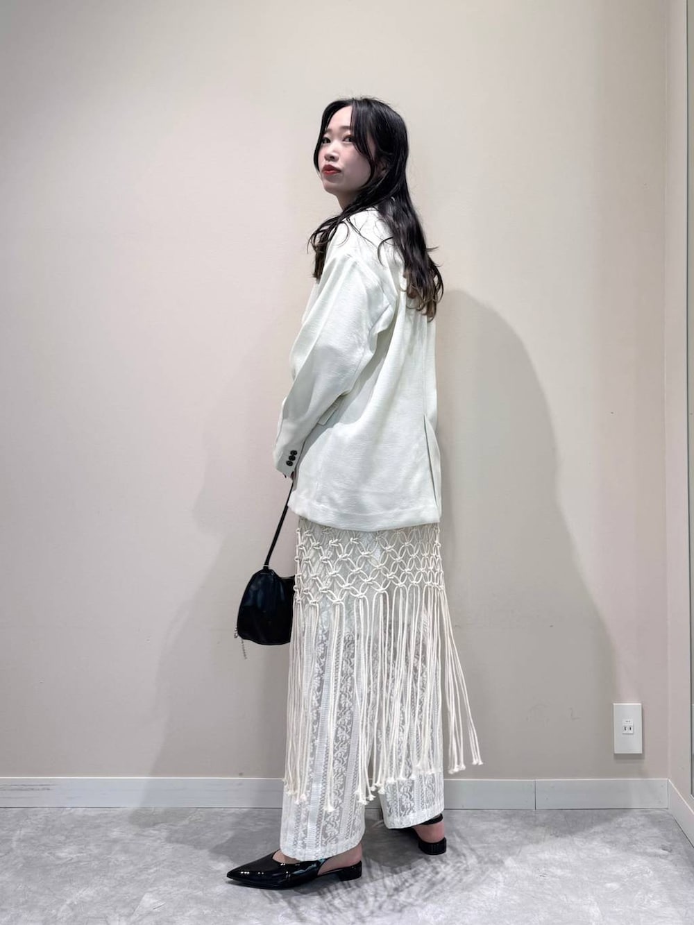 ホワイト系のテーラードジャケット、ホワイト系のTシャツ/カットソー、ブラック系のトートバッグを着用したレディースの春コーディネートの3枚目の写真