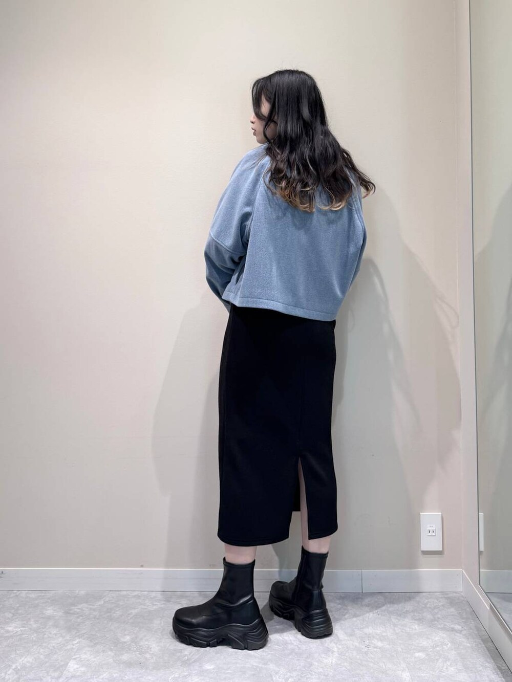 ブラック系のブーツ、シルバー系のショルダーバッグ、ブラック系のワンピースを着用したレディースの冬コーディネートの4枚目の写真