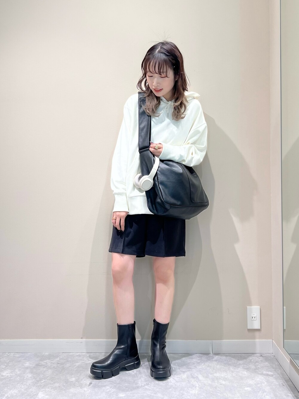 ブラック系のその他パンツ、ブラック系のバッグ、ホワイト系のパーカーを着用したレディースの春コーディネートの3枚目の写真