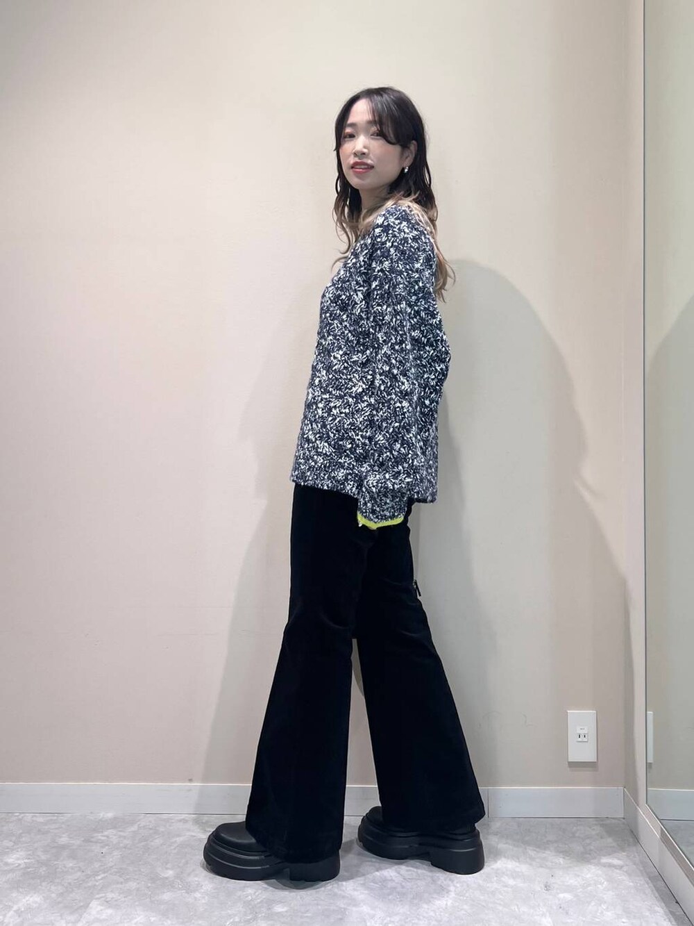 ブルー系のニット/セーター、ブラック系のブーツ、ブラック系のボストンバッグを着用したレディースの秋コーディネートの3枚目の写真