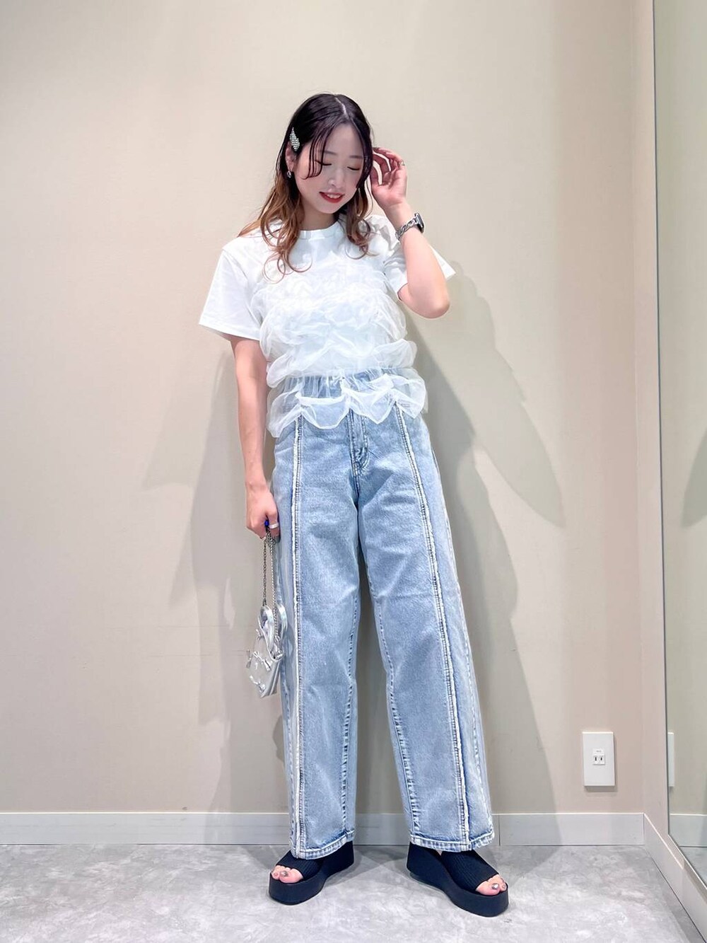 シルバー系のショルダーバッグ、ブルー系のデニムパンツ、ホワイト系のTシャツ/カットソーを着用したレディースの夏コーディネートの3枚目の写真