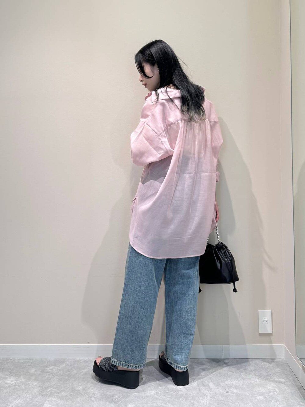 ブラック系のサンダル、ブルー系のデニムパンツ、ホワイト系のタンクトップを着用したレディースの夏コーディネートの3枚目の写真