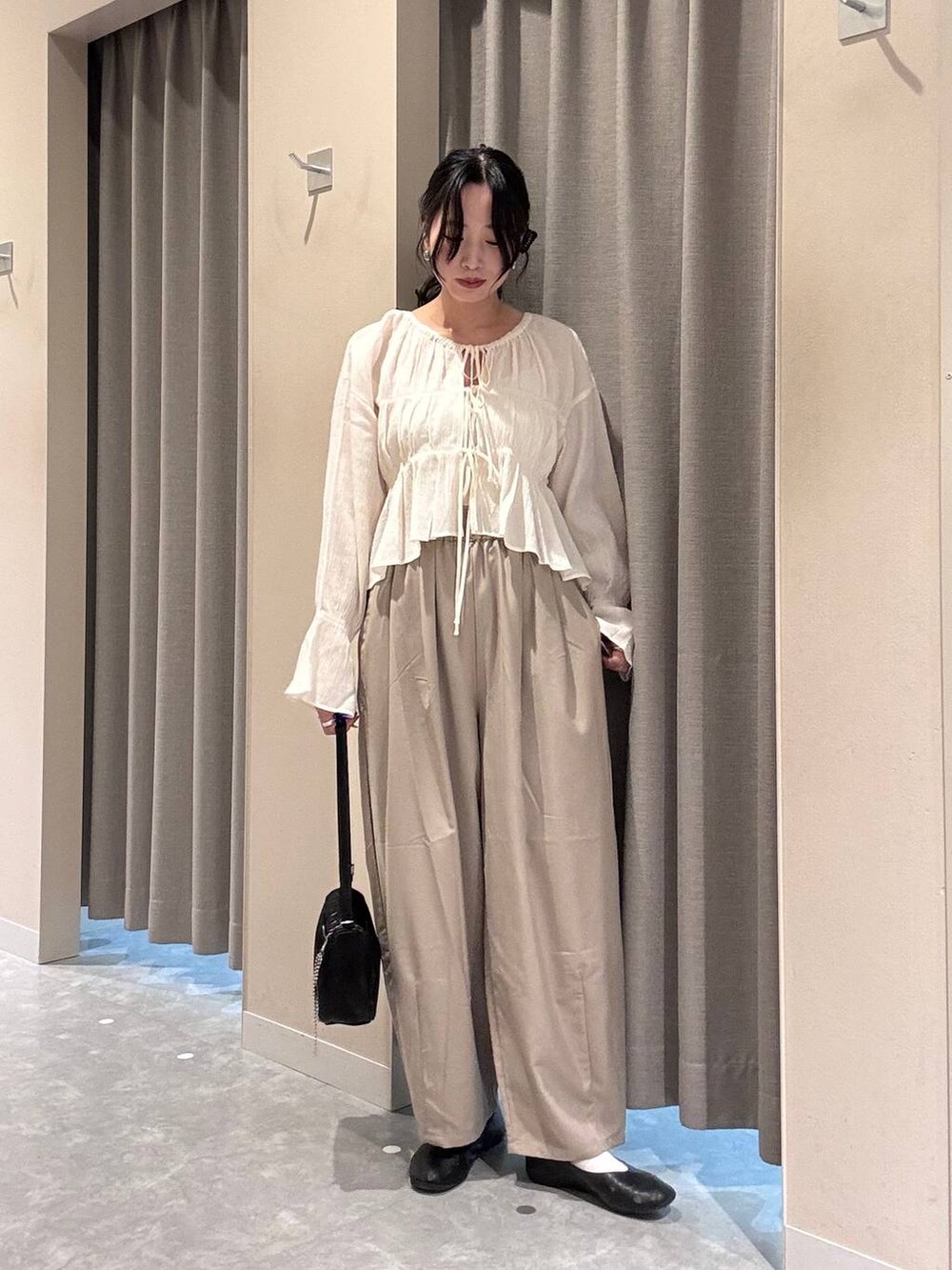 ブラック系のトートバッグ、ホワイト系のシャツ/ブラウス、ベージュ系のその他パンツを着用したレディースの春コーディネートの2枚目の写真