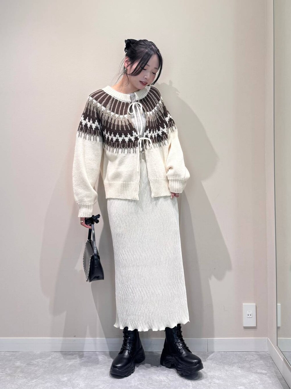 ブラック系のショルダーバッグ、ホワイト系のTシャツ/カットソー、ホワイト系のスカートを着用したレディースの冬コーディネートの4枚目の写真