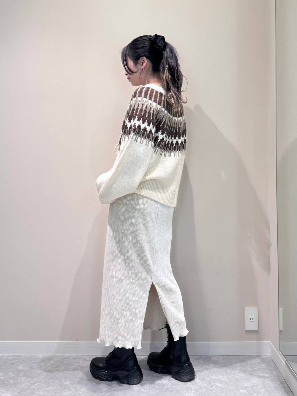 ブラック系のショルダーバッグ、ホワイト系のTシャツ/カットソー、ホワイト系のスカートを着用したレディースの冬コーディネートの5枚目の写真