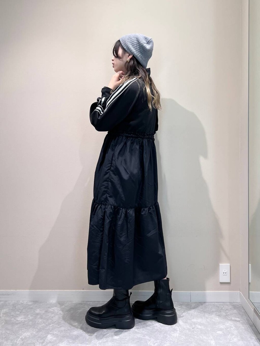 ブラック系のブーツ、ブラック系のショルダーバッグ、ブラック系のワンピースを着用したレディースの冬コーディネートの4枚目の写真