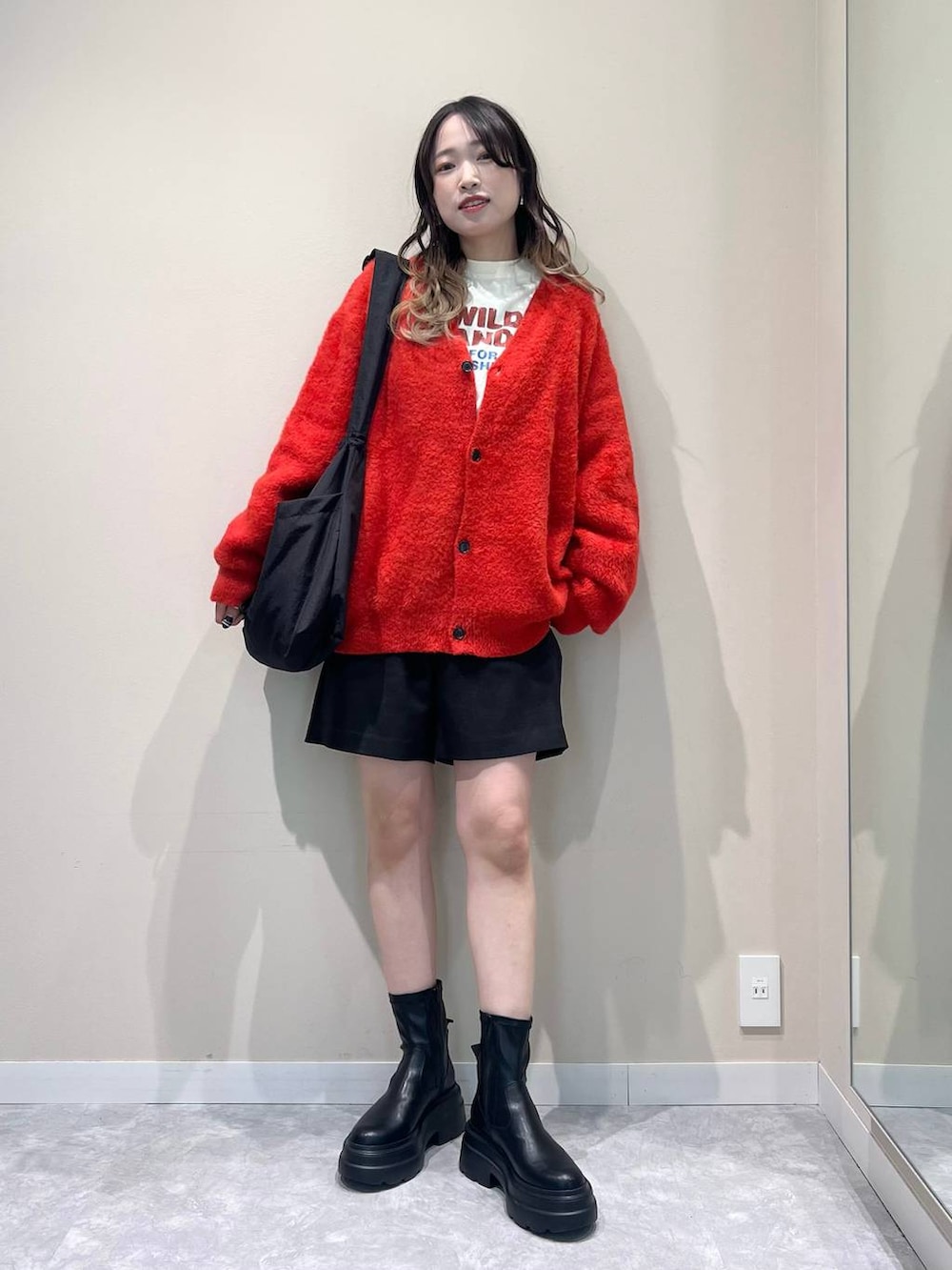 ブラック系のその他パンツ、ブラック系のブーツ、ホワイト系のTシャツ/カットソーを着用したレディースの冬コーディネートの2枚目の写真