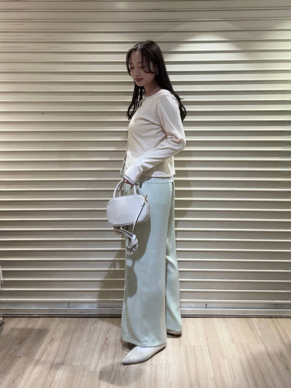 ホワイト系のボストンバッグ、ホワイト系のパンプス、グリーン系のその他パンツを着用したレディースの春コーディネートの2枚目の写真