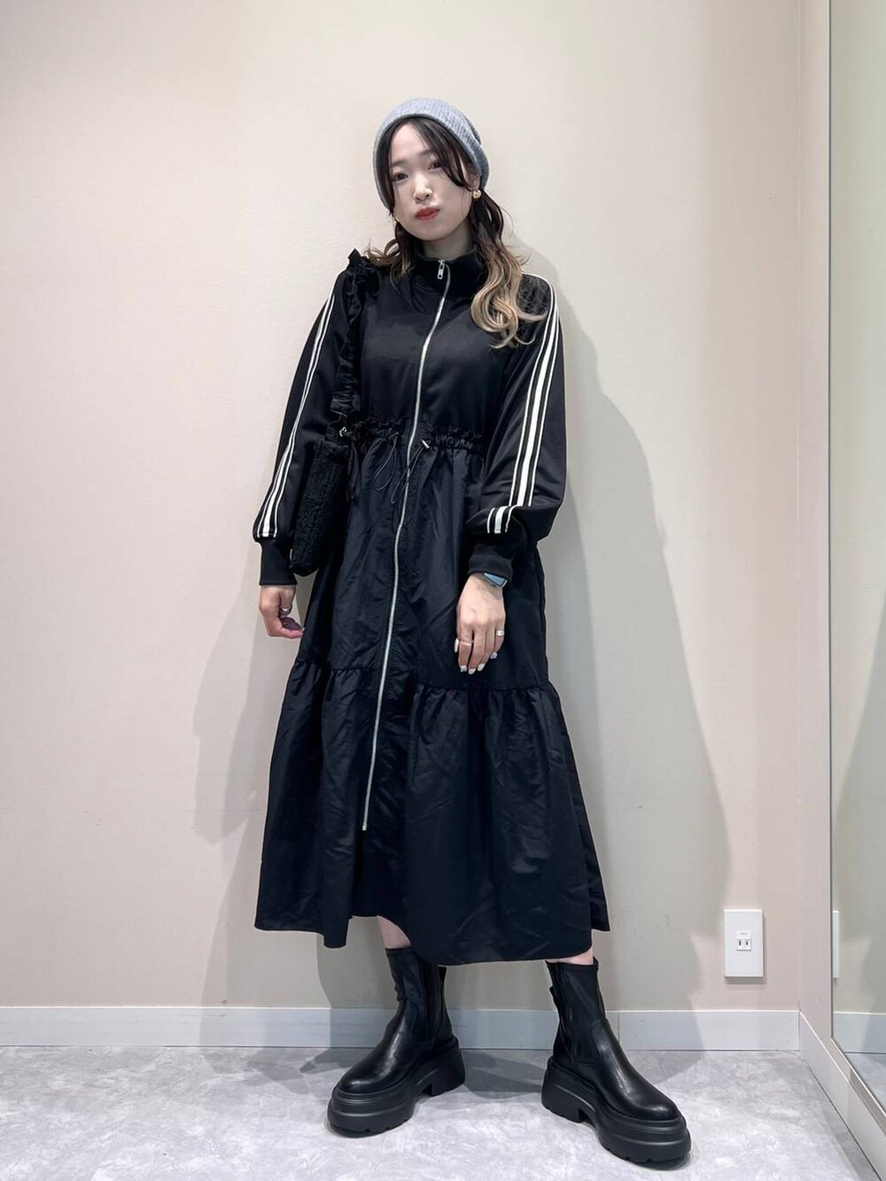 ブラック系のブーツ、ブラック系のショルダーバッグ、ブラック系のワンピースを着用したレディースの冬コーディネートの5枚目の写真