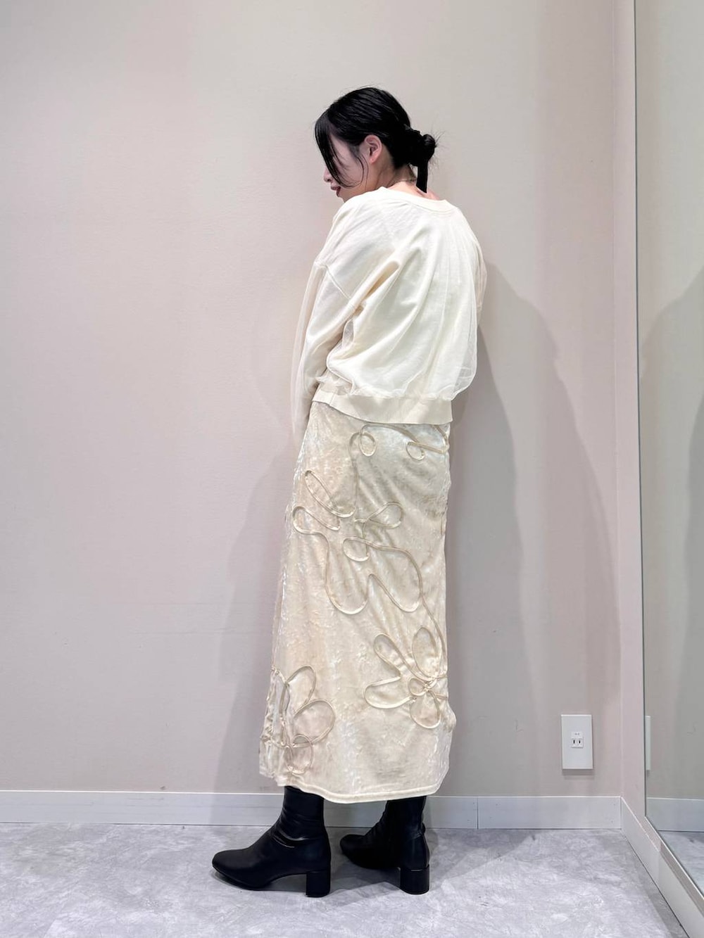 ホワイト系のニット/セーター、ブラック系のブーツ、ブラウン系のショルダーバッグを着用したレディースの秋コーディネートの2枚目の写真