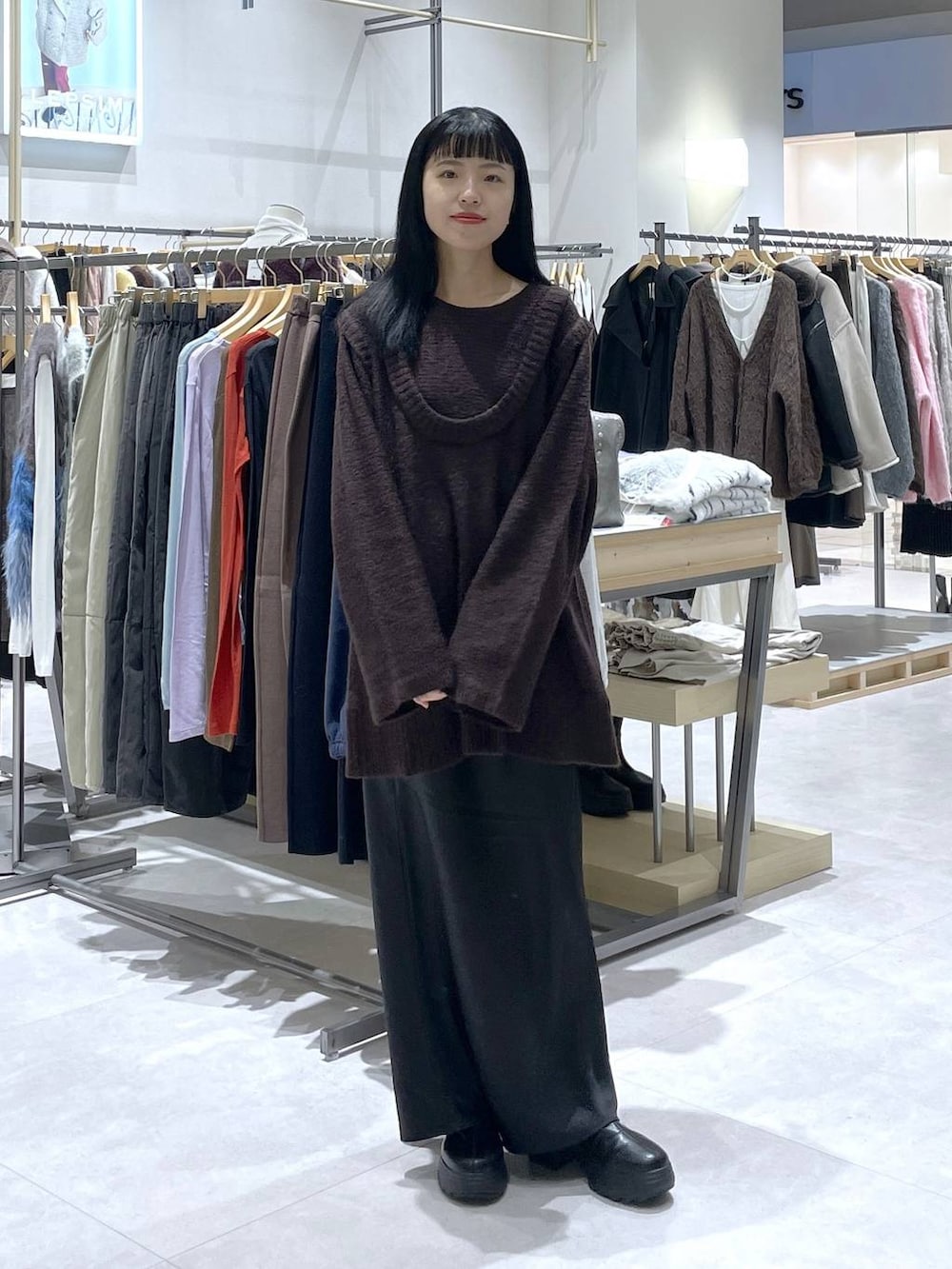 ブラック系のスカート、ブラック系のブーツを着用したレディースの冬コーディネートの5枚目の写真