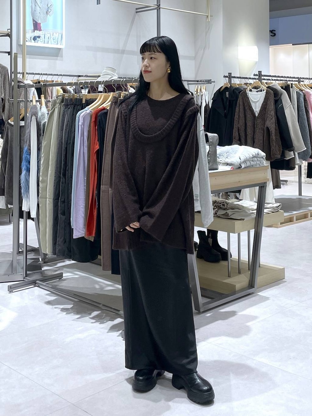 ブラック系のスカート、ブラック系のブーツを着用したレディースの冬コーディネートの2枚目の写真