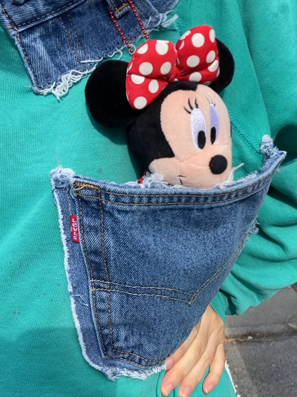 グリーン系のスウェット、ブルー系のデニムパンツ、レッド系のスニーカーを着用したレディースの冬コーディネートの4枚目の写真