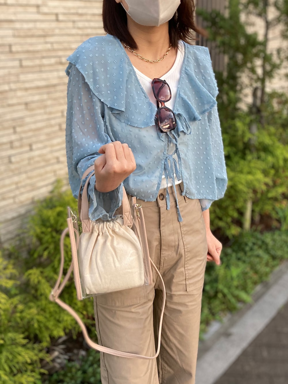 ブルー系のシャツ/ブラウス、ホワイト系のサンダル、ベージュ系のバッグを着用したレディースの春コーディネートの3枚目の写真