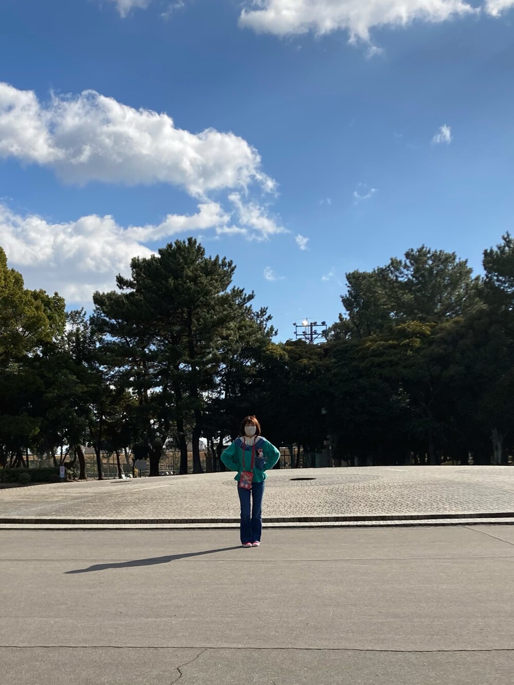 グリーン系のスウェット、ブルー系のデニムパンツ、レッド系のスニーカーを着用したレディースの冬コーディネートの2枚目の写真