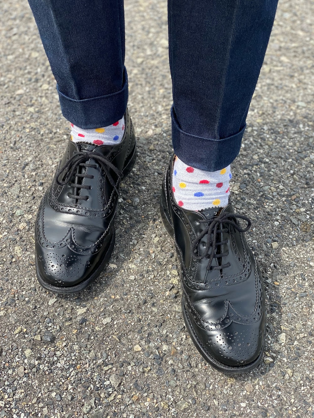 ブルー系のデニムパンツ、ベージュ系のステンカラーコート、グレー系のニット/セーターを着用したメンズの春コーディネートの2枚目の写真