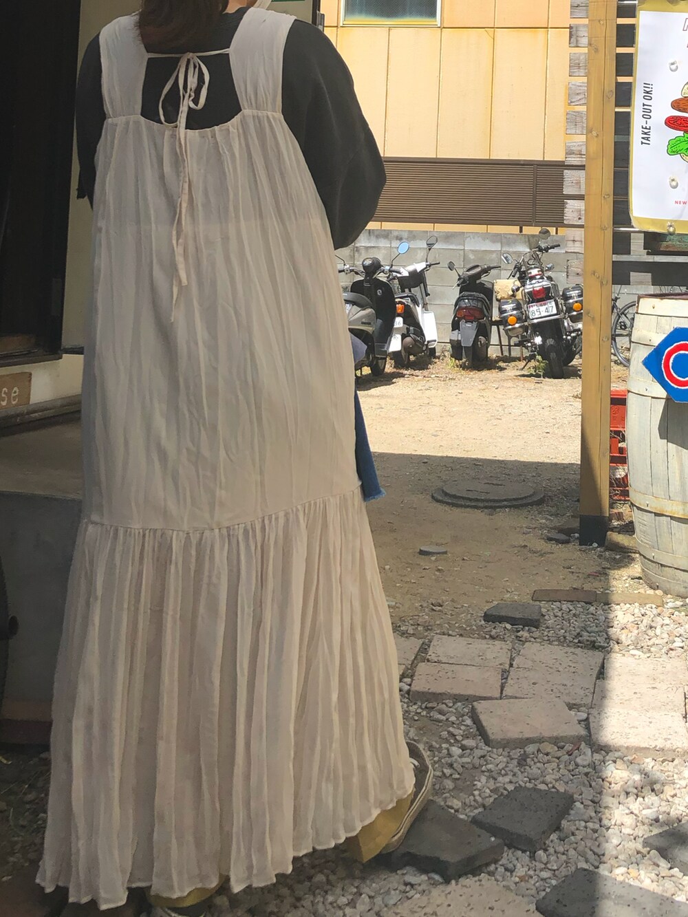 イエロー系のショルダーバッグ、ホワイト系のワンピースを着用したレディースの冬コーディネートの3枚目の写真