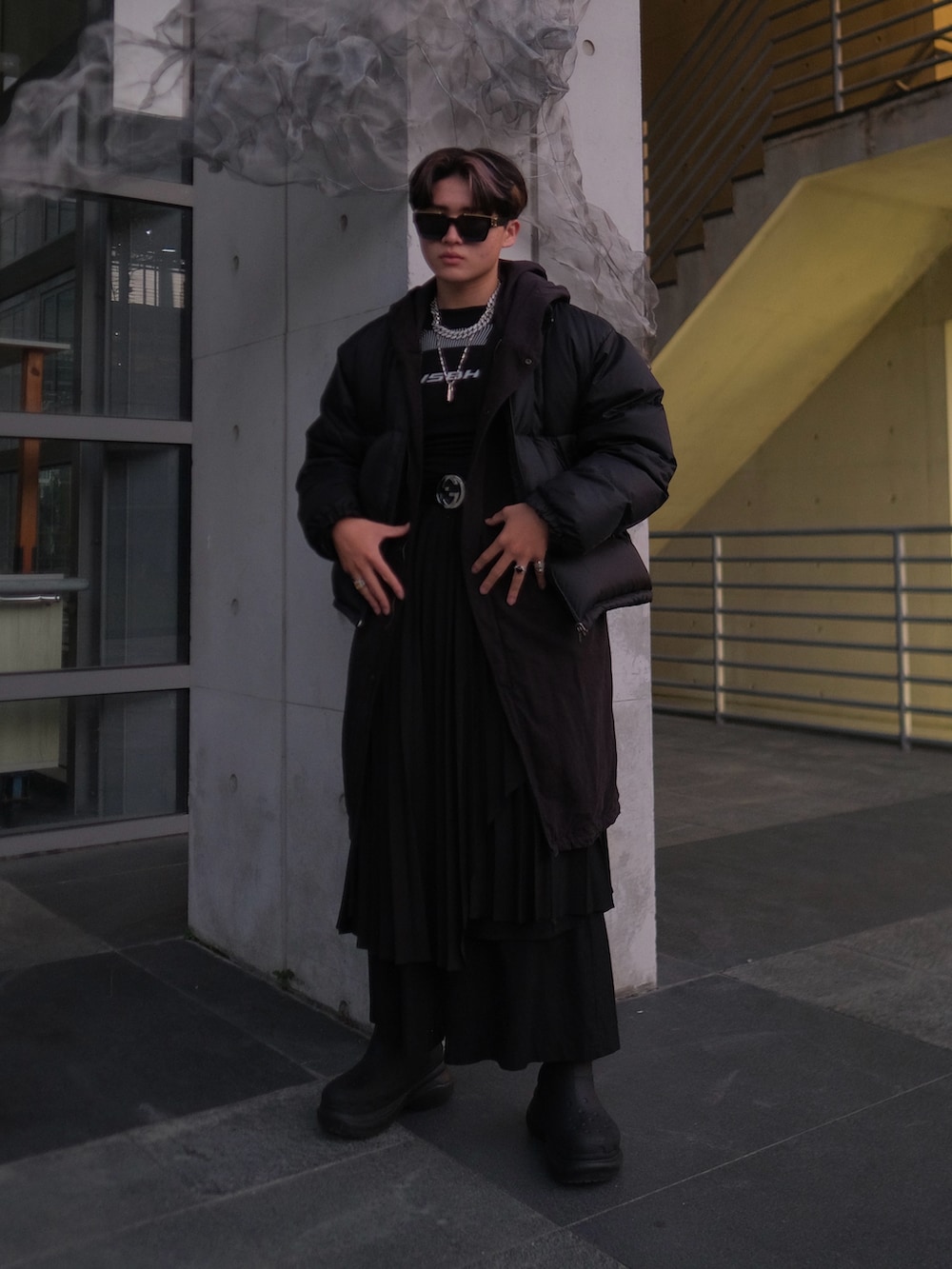 ブラック系のブーツ、ブラック系のトップス、ブラック系のベルトを着用したメンズの冬コーディネートの3枚目の写真