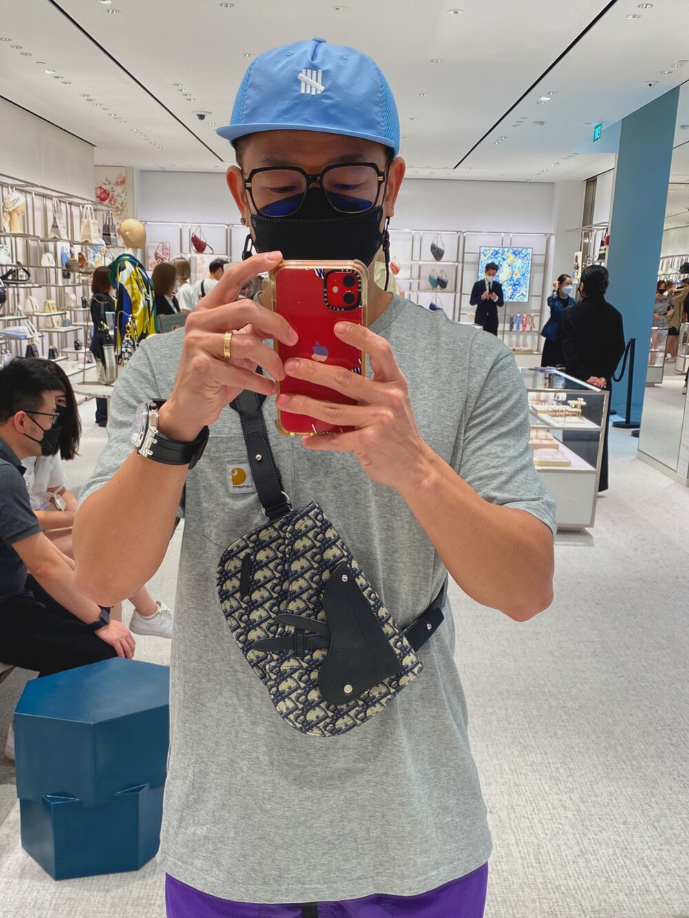 ブラック系のメッセンジャーバッグ、グレー系のTシャツ/カットソー、パープル系のパンツを着用したメンズの冬コーディネートの2枚目の写真