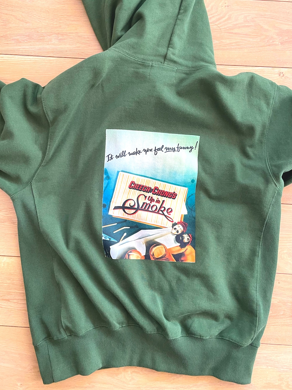 グリーン系のパーカー、ブラック系のパンツ、ブラック系のスニーカーを着用したメンズの秋コーディネートの2枚目の写真