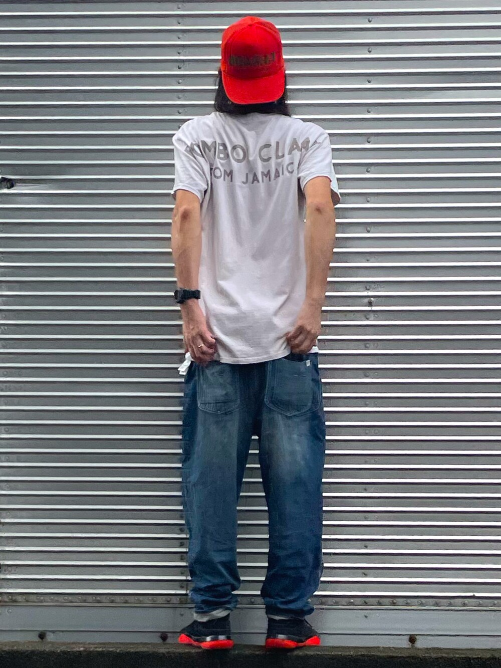 ピンク系のTシャツ/カットソー、ブルー系のデニムパンツ、ブラック系のスニーカーを着用したメンズの秋コーディネートの2枚目の写真