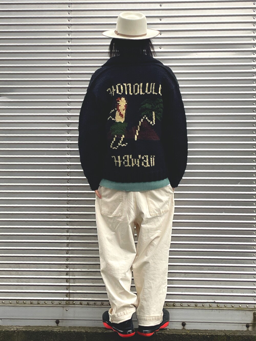 ホワイト系のパンツ、グリーン系のニット/セーター、ブラック系のジャケット/アウターを着用したメンズの冬コーディネートの2枚目の写真