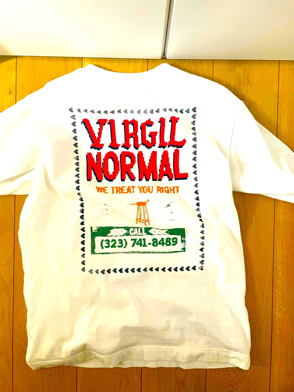 ホワイト系のTシャツ/カットソー、ブルー系のデニムパンツ、ブラック系のスニーカーを着用したメンズの秋コーディネートの2枚目の写真