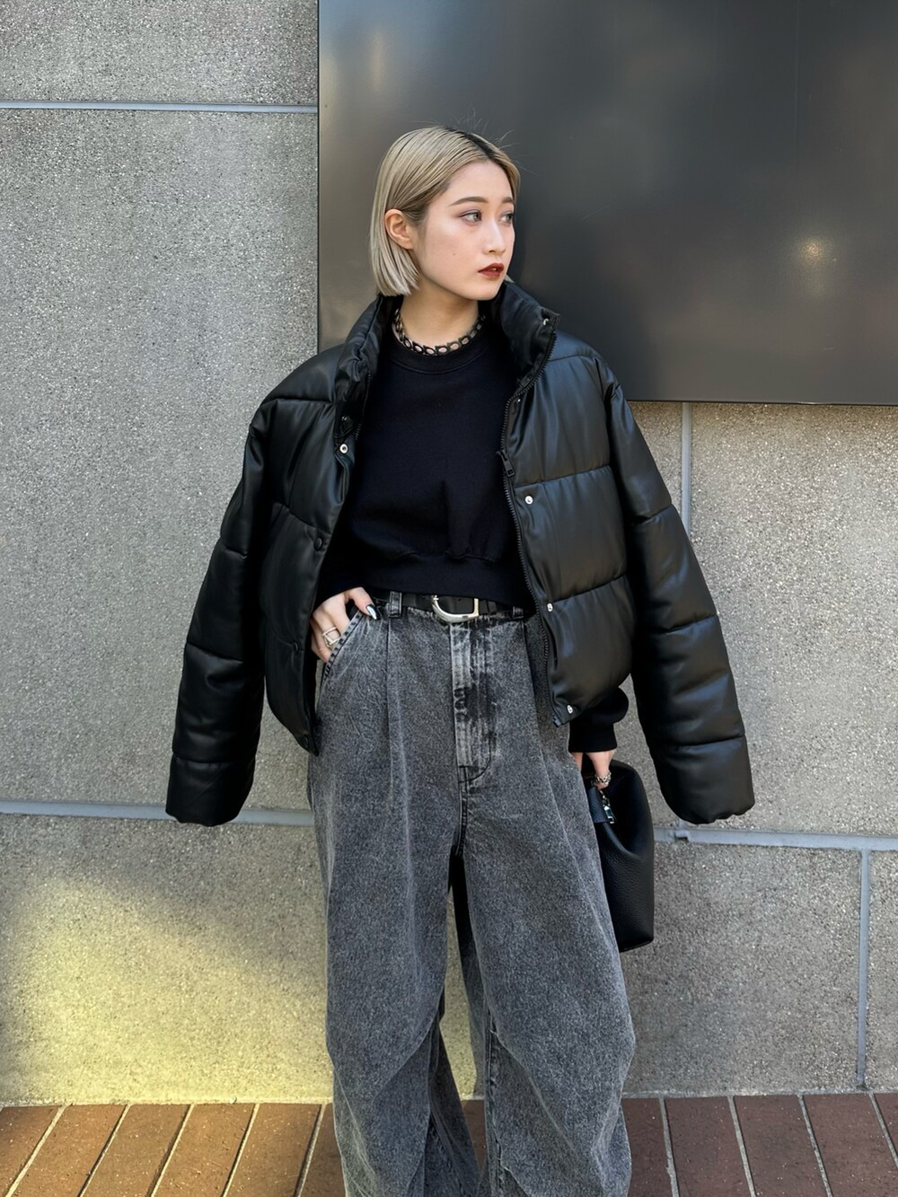 ブラック系のショルダーバッグ、ブラック系のデニムパンツを着用したレディースの冬コーディネートの2枚目の写真