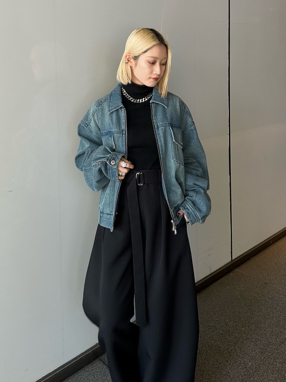 ブルー系のデニムジャケット、ブラック系のニット/セーター、ブラック系のスラックスを着用したレディースの冬コーディネートの4枚目の写真