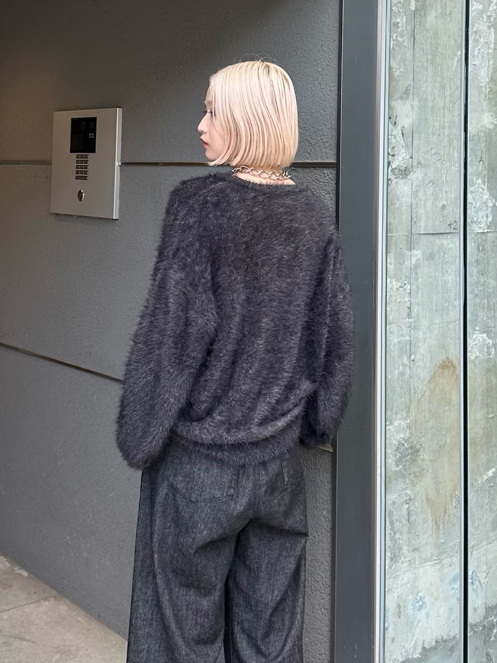 ブラック系のニット/セーター、ブラック系のデニムパンツ、シルバー系のネックレスを着用したレディースの秋コーディネートの6枚目の写真