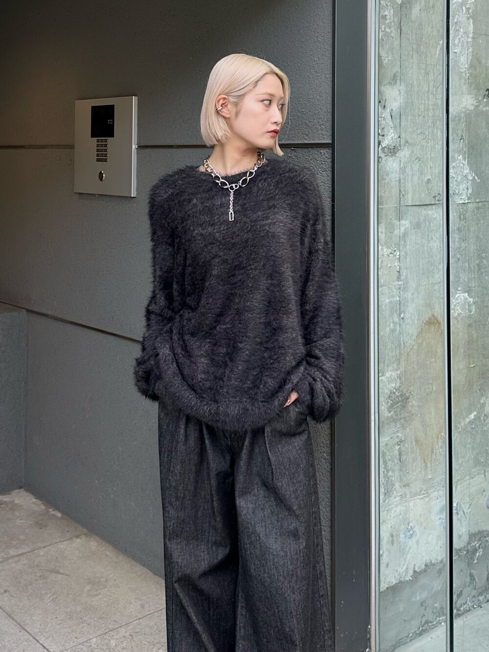 ブラック系のニット/セーター、ブラック系のデニムパンツ、シルバー系のネックレスを着用したレディースの秋コーディネートの5枚目の写真