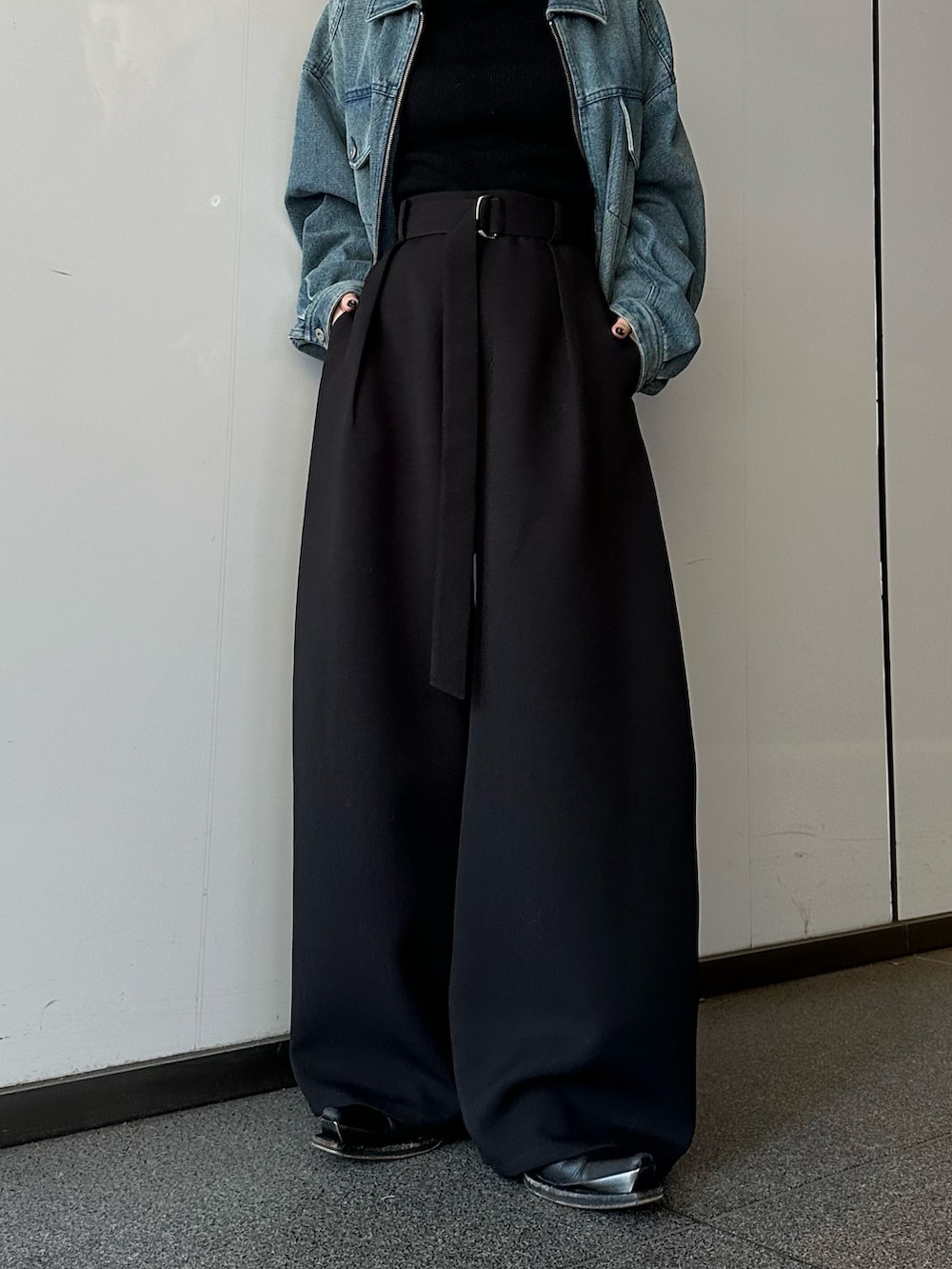 ブルー系のデニムジャケット、ブラック系のニット/セーター、ブラック系のスラックスを着用したレディースの冬コーディネートの7枚目の写真